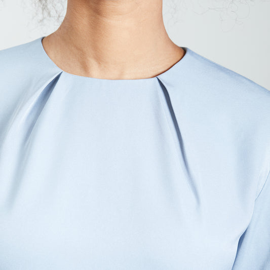 Detail view of the neck pleats on an ice blue dress